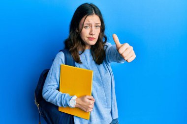 Öğrenci sırt çantası takan esmer, genç bir bayan şüpheli ve gergin, sorun yüzünden surat asıyor. negatif kişi. 