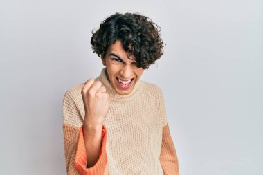 Hispanik genç adam öfkeyle bağırırken kızgın ve kızgın yumruk kaldırıyor. öfke ve agresif konsept. 