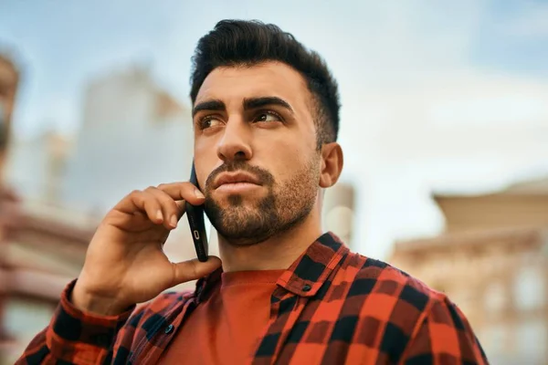 Joven Hombre Hispano Con Expresión Seria Hablando Smartphone Ciudad —  Fotos de Stock