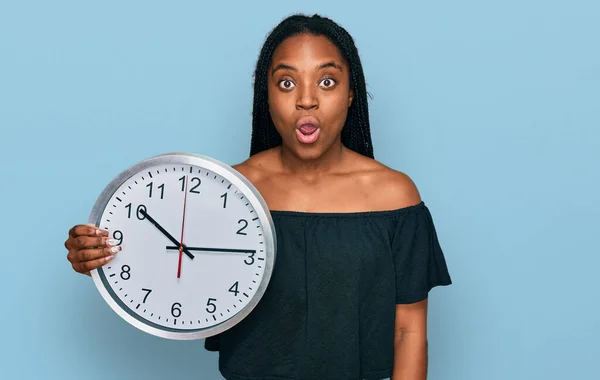 Młoda Afroamerykanka Trzyma Duży Zegar Przerażony Zdumiony Otwartymi Ustami Dla — Zdjęcie stockowe