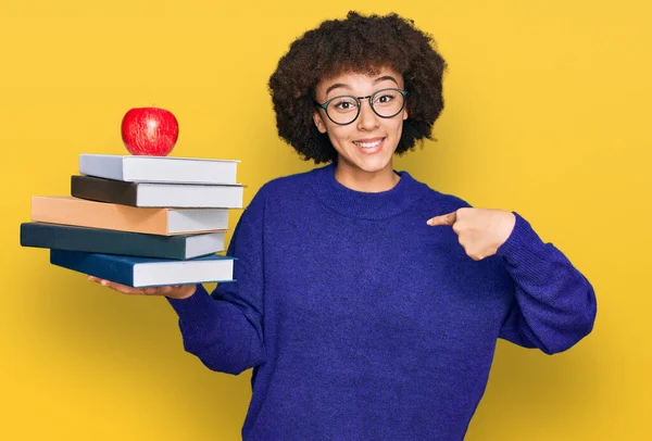 Young Hispanic Girl Wearing Glasses Holding Books Red Apple Pointing — Stock Photo, Image