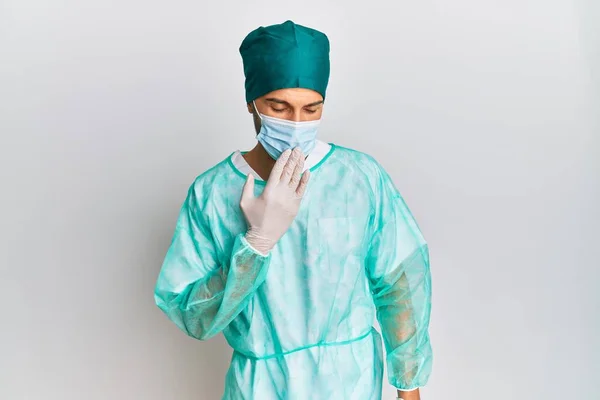 Fiatal Jóképű Férfi Sebész Egyenruhában Orvosi Maszkban Unatkozva Ásítozik Kézzel — Stock Fotó