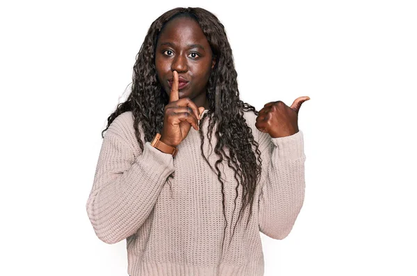 ウールの冬のセーターを着ている若いアフリカの女性は 唇に手で側に指して指で静かになるように求めています 沈黙と秘密の概念 — ストック写真