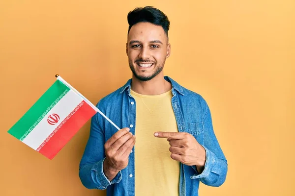 Mladý Arabský Muž Držící Íránskou Vlajku Úsměvem Ukazuje Rukou Prstem — Stock fotografie