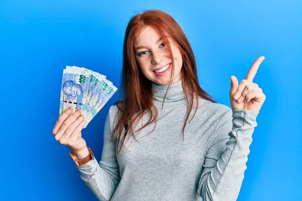 Joven Chica Pelirroja Sosteniendo Billetes Sudafricanos 100 Rand Sonriendo Feliz — Foto de Stock