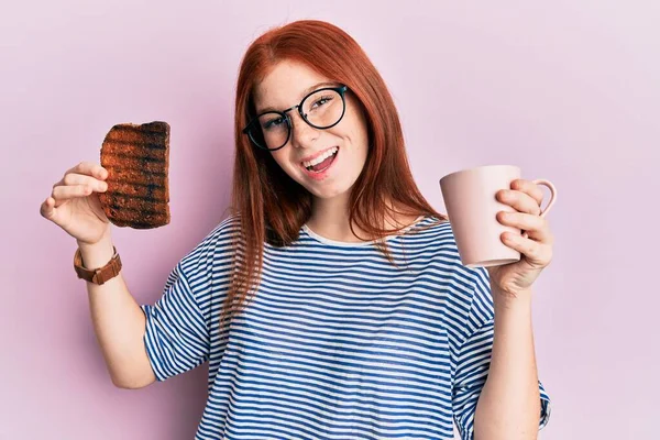 Joven Chica Pelirroja Sosteniendo Tostadas Quemadas Para Desayuno Sonriendo Riendo —  Fotos de Stock