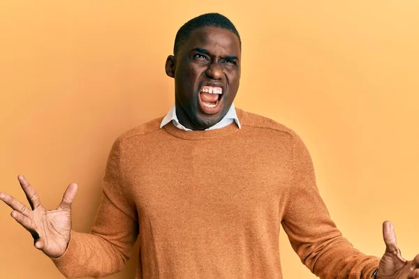 若いアフリカ系アメリカ人の男性は カジュアルな服を着て狂気と怒りの叫びと積極的な表現と腕を上げて叫んでいた フラストレーションコンセプト — ストック写真