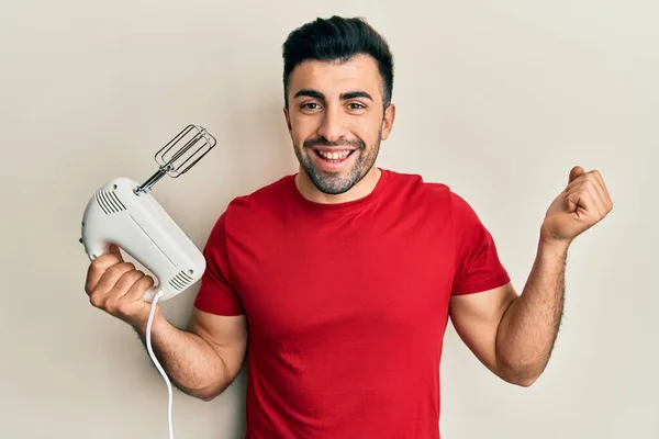 Homem Hispânico Jovem Segurando Máquina Misturadora Processador Alimentos Gritando Orgulhoso — Fotografia de Stock