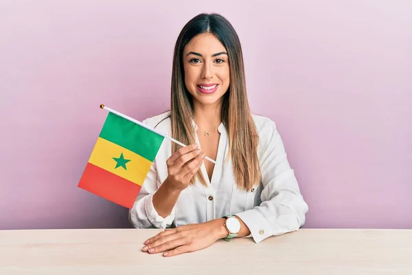 Jovem Hispânica Segurando Bandeira Senegal Sentado Mesa Olhando Positivo Feliz — Fotografia de Stock