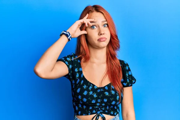 Młoda Piękna Ruda Kobieta Ubrana Luźne Ubrania Niebieskim Tle Zaniepokojona — Zdjęcie stockowe