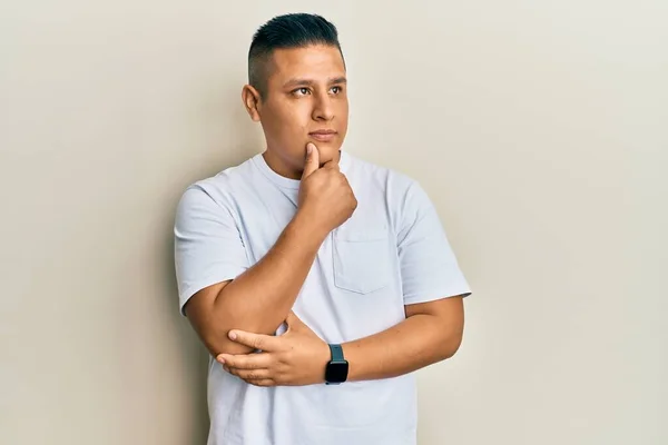 Hombre Latino Joven Con Camiseta Blanca Casual Con Mano Barbilla —  Fotos de Stock