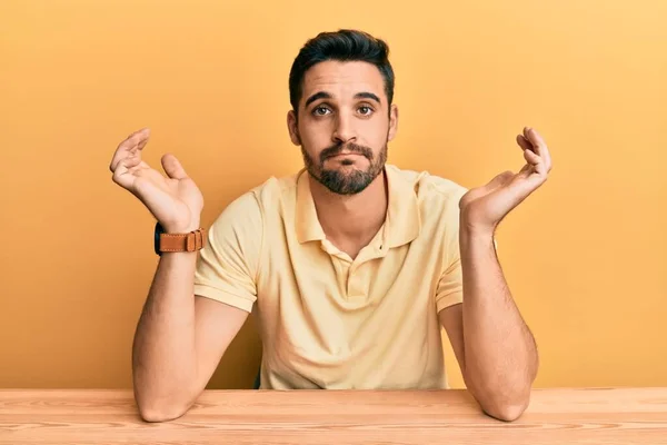 Jovem Hispânico Vestindo Roupas Casuais Sentado Mesa Expressão Indolor Confuso — Fotografia de Stock