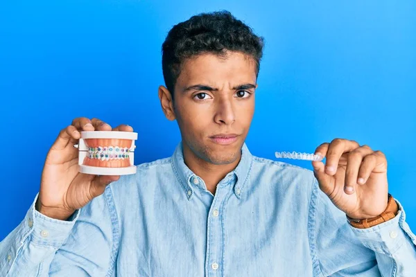 Joven Hombre Afroamericano Guapo Sosteniendo Alineador Invisible Ortodoncia Frenos Escéptico — Foto de Stock