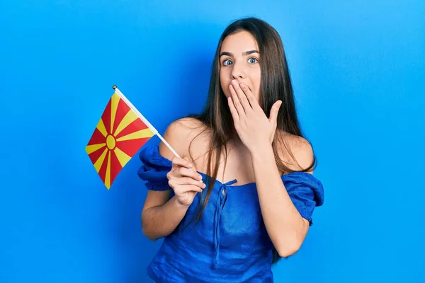 Young Brunette Teenager Holding Macedonian Flag Covering Mouth Hand Shocked — Stock Photo, Image