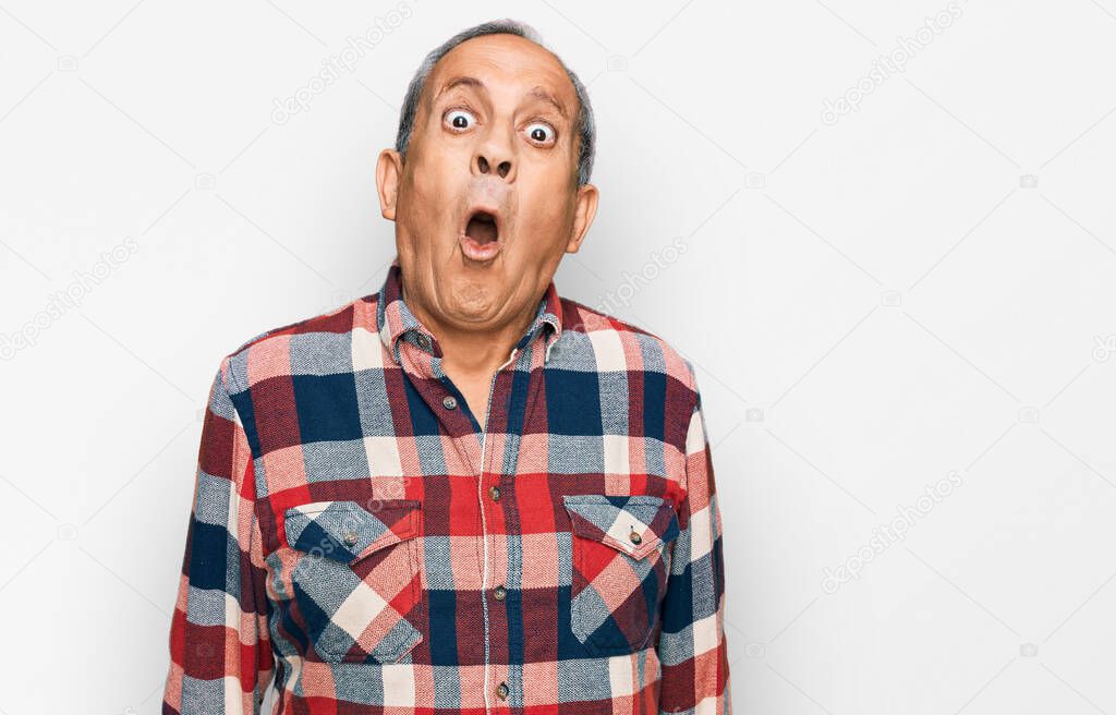 Senior hispanic man wearing casual clothes scared and amazed with open mouth for surprise, disbelief face 