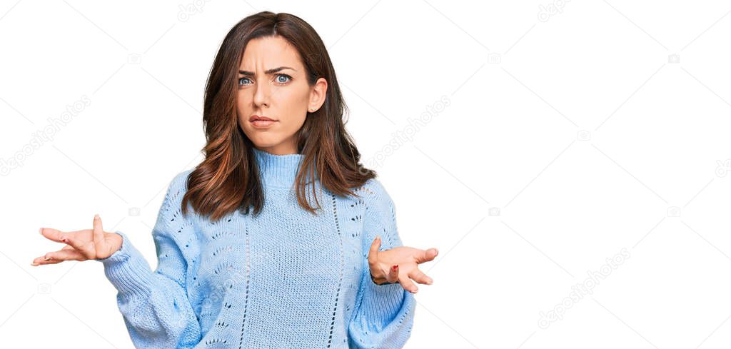 Young brunette woman wearing casual winter sweater clueless and confused with open arms, no idea concept. 
