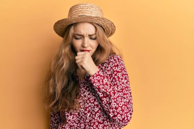 Yazlık şapka takan güzel sarışın kadın kendini iyi hissetmiyor ve soğuk algınlığı veya bronşitin belirtisi olarak öksürüyor. sağlık hizmeti kavramı. 