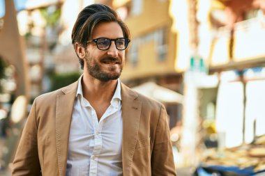 Genç İspanyol işadamı gülümseyerek şehirde mutlu mesut duruyor..