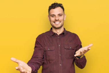 Gündelik kıyafetler giyen, neşeli gülümseyen, yardım eli uzatan ve kabullenen genç İspanyol adam.. 