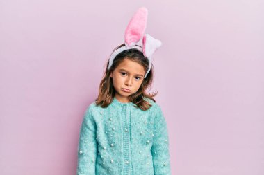 Paskalya tavşanı kulakları takan küçük güzel bir kız üzgün ve endişeli, sinirli ve korkmuş bir şekilde ağlıyor. hüzünlü ifade. 