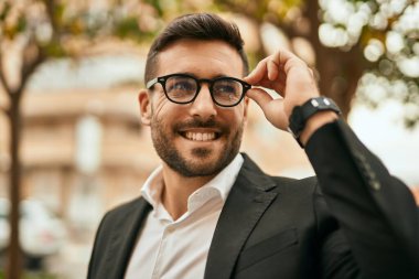Genç İspanyol işadamı gülümseyerek şehirde mutlu mesut duruyor..