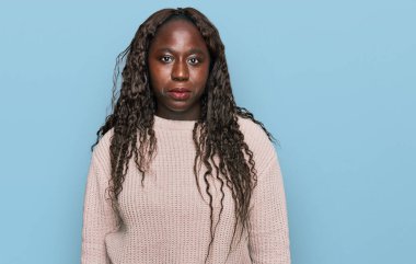 Kışın yün kazak giyen Afrikalı genç bir kadın sıkıntılı ve endişeli, sinirli ve korkmuş bir şekilde ağlıyor. hüzünlü ifade. 