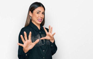 Gündelik kıyafetler giyen genç İspanyol kadın tiksinti ifadesi takınıyordu. Tiksinti tepki verdiği için tiksinmiş ve korkmuş bir ifade takınıyordu. Eller havada. 