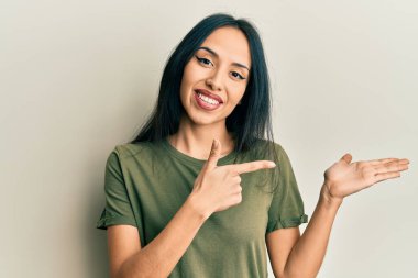 Gündelik tişört giyen genç İspanyol kız kameraya hayret ediyor ve gülümsüyor.. 