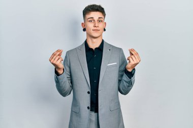 Kulakları genişlemiş, iş ceketi giyen, elleriyle para hareketi yapan, maaşını isteyen, milyonerlik işi yapan beyaz bir çocuk. 