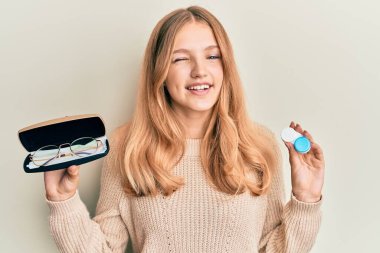 Güzel, genç, beyaz, gözlüklü, kontak lensli bir kız kameraya seksi bir ifadeyle bakıyor, neşeli ve mutlu bir yüz.. 