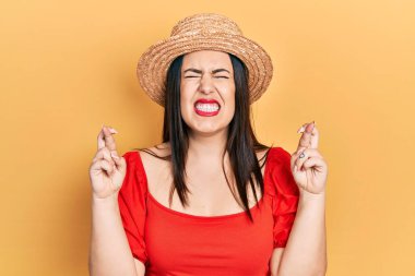 Yaz şapkası takan genç İspanyol kadın umut ve gözlerin kapalı bir şekilde gülümseyerek bana işaret etti. Şans ve batıl inançlar. 