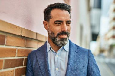 Orta yaşlı işadamı şehirde mutlu mesut dikilirken.