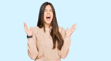 Kışlık süveter giyen genç esmer kadın başarının çılgınlığını kollarını kaldırmış ve gözlerini kapatmış heyecanlı bir şekilde haykırarak kutluyor. Kazanan konsept 