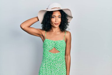 Yaz şapkası takan genç Latin kız soru sormayı merak ediyor. Şüpheyle kararsız, kafa kafaya düşünerek. Düşünceli kavram. 