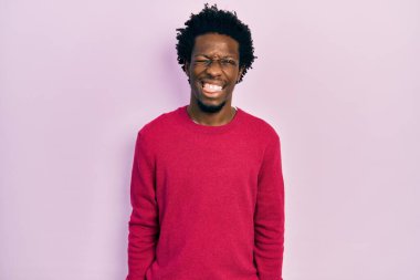 Genç, Afro-Amerikan bir adam günlük kıyafetler giyiyor. Dilini komik bir ifadeyle dışarı çıkarıyor. duygu kavramı. 