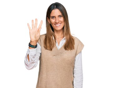 Gündelik kıyafetler giyen genç bir kadın gülümseyerek kendinden emin ve mutlu bir şekilde dört numarayı işaret ediyor.. 