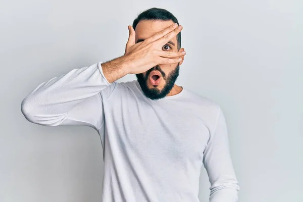 Jovem Com Barba Vestindo Camisa Branca Casual Espreitando Choque Cobrindo — Fotografia de Stock