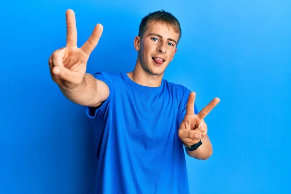 Young Caucasian Man Wearing Casual Blue Shirt Smiling Tongue Out — Stock Photo, Image