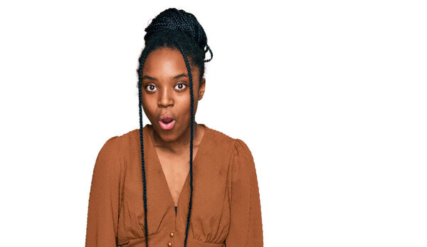 Молодая африканская американка в повседневной одежде, напуганная и шокированная неожиданным выражением, страхом и возбужденным лицом. 