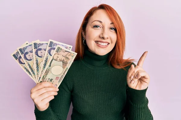 Mulher Ruiva Bonita Segurando Notas Iene Japonês Sorrindo Feliz Apontando — Fotografia de Stock