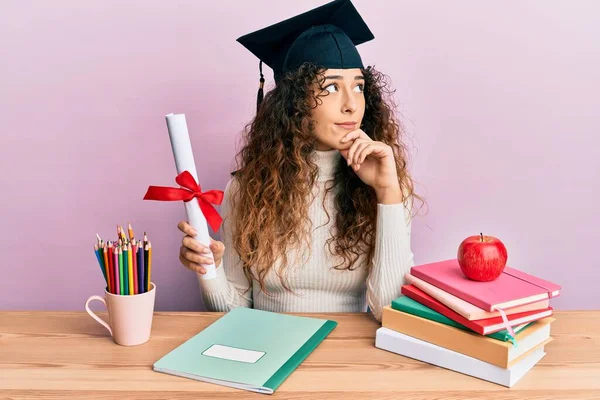 Joven Chica Hispana Usando Sombrero Graduado Sosteniendo Diploma Cara Seria — Foto de Stock