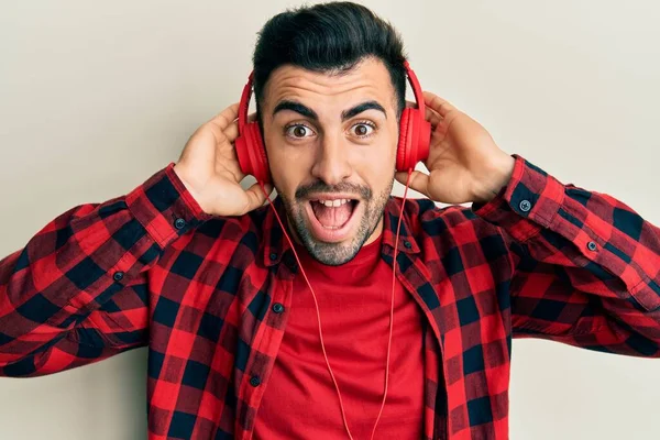 Young Hispanic Man Listening Music Using Headphones Celebrating Crazy Amazed — Stock Photo, Image