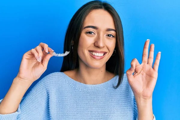 Young Hispanic Girl Holding Invisible Aligner Orthodontic Doing Sign Fingers — Stock Photo, Image