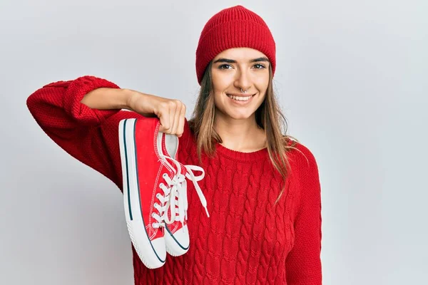赤のカジュアルな靴を持っている若いヒスパニック系の女性はポジティブで幸せな立っていると笑顔で自信を持って笑顔を見せて歯 — ストック写真