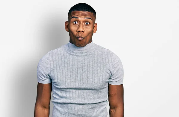狂気とコミカルなジェスチャーで魚の顔を作るカジュアルなTシャツを着て若い黒人男性 面白い表現 — ストック写真