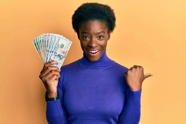 Молода Афроамериканська Дівчина Тримає Долари Показуючи Великий Палець Бік Посміхаючись — стокове фото