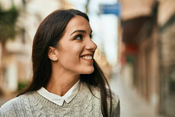 若いヒスパニック系の女性が幸せそうに街に立って笑っている — ストック写真