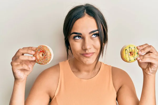 Mladá Brunetka Žena Drží Chutné Barevné Koblihy Úsměvem Dívá Strany — Stock fotografie