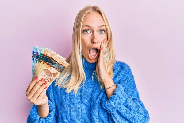 Mladá Blondýnka Drží Kanadské Dolary Strach Šok Překvapení Užaslý Výraz — Stock fotografie