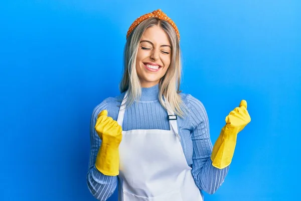 Beautiful Blonde Woman Wearing Cleaner Apron Gloves Excited Success Arms — Stock Photo, Image